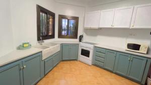 una cucina con armadi blu ed elettrodomestici bianchi di Villa Bobal a Requena