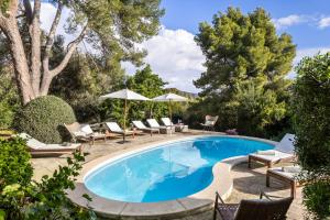 a swimming pool with lounge chairs and umbrellas next to a yard at Lovehaus Terra Rotja in Esporles