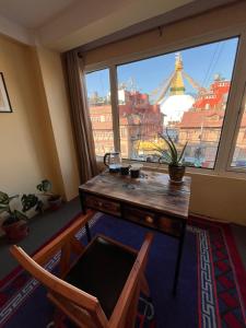 a room with a table and chairs and a large window at Front Stupa View in Kathmandu