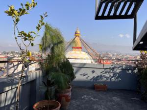 a view of a tower from a balcony with plants at Front Stupa View in Kathmandu