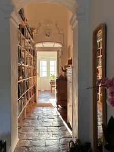 a hallway with a stone floor and a room with bookshelves at Casa no Montinho in Ourique