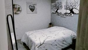 a bedroom with a bed and some pictures on the wall at Jujuouragan 2 in Saint Die