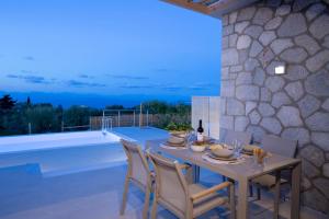 a dining room with a table and chairs on a patio at Ionian Harmony in Tsoukaladhes
