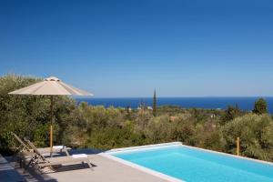 a swimming pool with an umbrella and chairs and a swimming pool at Ionian Harmony in Tsoukaladhes
