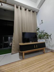 a living room with a flat screen tv on a table at Suite U Studio 108 in Kota Bharu