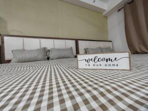a bed with a welcome to our home sign on it at Suite U Studio 108 in Kota Bharu +2 photos