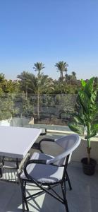 a white table and two chairs on a patio at Nakhil Pyramids Resort in Cairo
