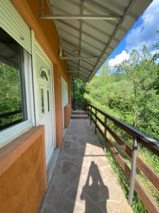 a shadow of a person standing on the porch of a house at Apartmani Stajko in Crni Vrh