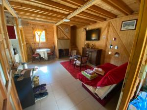 a living room with a red couch and a table at Planinska Idila in Crni Vrh
