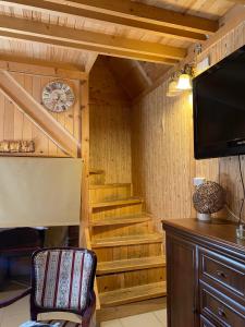 a room with stairs and a clock and a tv at Apartmani Stajko in Crni Vrh