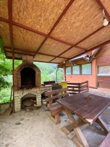 a patio with a picnic table and a fireplace at Apartmani Stajko in Crni Vrh