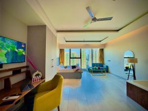 Nabhay Hotels and Resorts في غازي آباد: غرفة معيشة مع أريكة وتلفزيون بشاشة مسطحة