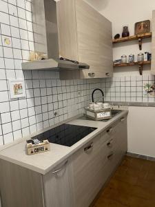 Madonna dell'ancora في ساسوولو: مطبخ بجدران بيضاء من البلاط ودواليب بيضاء