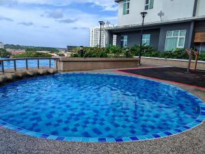 a large blue swimming pool in front of a building at Suite U Studio 108 in Kota Bharu