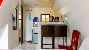 a small kitchen with two chairs in a tiny house at Filmegs Seaside in Alegria