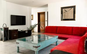 ein Wohnzimmer mit einem roten Sofa und einem Couchtisch aus Glas in der Unterkunft Bikini Bottom Villa by Utalay Koh Chang in Ban Khlong Son