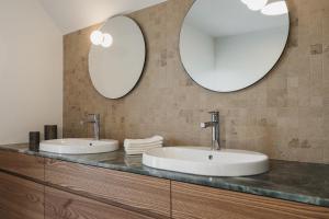 two sinks in a bathroom with two mirrors at Das Dietrich - Landhaus 62 in Leibnitz +55 photos