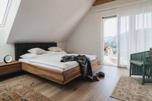 a bedroom with a bed and a large window at Das Dietrich - Landhaus 62 in Leibnitz