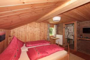 a bedroom with a bed with red pillows at Haus am Rain in Partenen
