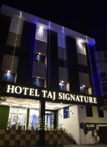 a hotel tar signature sign in front of a building at Hotel Taj Signature in Tājganj