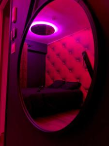 a room with a bed with a purple light at Love room avec jacuzzi privé in Bonnétable