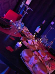 a table with wine glasses and a tray of food at Love room avec jacuzzi privé in Bonnétable +13 photos