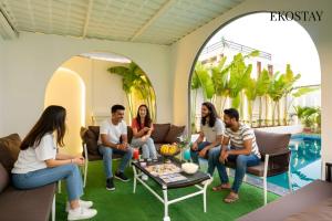 Un grupo de personas sentadas en una sala de estar en EKOSTAY - Azure Villa, en Lonavala