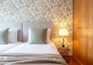 una camera da letto con un letto e una lampada su un tavolo di Funcho 91 - Spacious 100m2 Apt - Panoramic Views - Free Parking - Madeira a Funchal