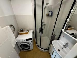 a bathroom with a shower and a washing machine at Apartments in Valmiera in Valmiera