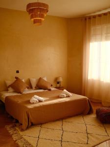 a bedroom with a large bed with towels on it at Catamaran Surf House in Imi Ouaddar