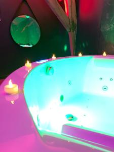 a bathroom with a tub with lights on it at Love room avec jacuzzi privé in Bonnétable