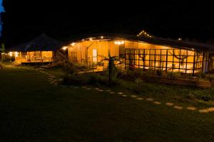 a wooden house with lights on it at night at Phong Nam Station in Bản Piên