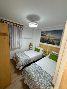 een hotelkamer met twee bedden en een raam bij Apartamento Arenal 1a Linea de Playa in Cullera