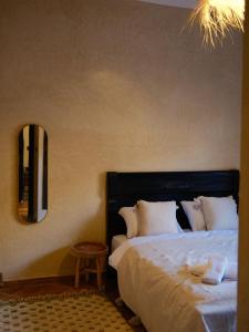 a bedroom with a large bed and a mirror at Catamaran Surf House in Agadir nʼ Aït Sa