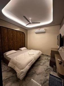 a bedroom with a large bed with a ceiling fan at Hotel kapil royal inn in Haridwār