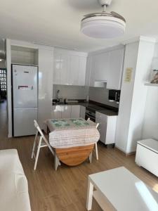 een keuken met een tafel in het midden van een kamer bij Apartamento Arenal 1a Linea de Playa in Cullera +9 foto's