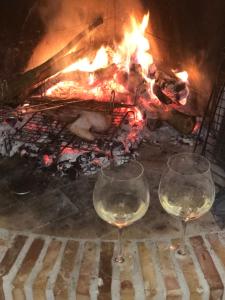 two glasses of white wine in front of a fire at Casale Kintsugi in Cepagatti +59 photos