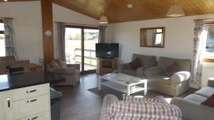 a living room with a couch and a tv at Avonvale Holiday Lodges, your home from home on the edge of THE COTSWOLDS in Evesham