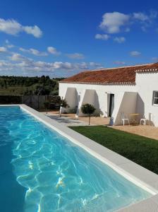 una villa con piscina frente a una casa en Casa no Montinho, en Ourique