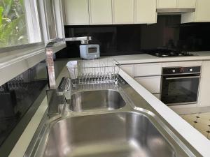 cocina con fregadero y tendedero de platos en Marsfield-Queen-MacUni-MacCentre-Bus-Woolworth, en Sídney 3 fotos más