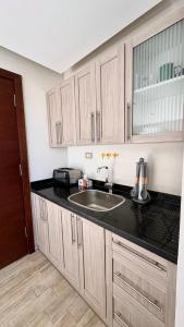 a kitchen with a sink and a counter top at Modern Rooftop Studio in Westown, Sheikh Zayed - Near GEM & SPX Airport in Sheikh Zayed +5 photos