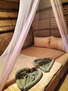 a bed with two blankets on top of it at Shah Hill Hut in Phra Ae beach