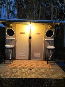 a bathroom with two sinks and two doors at Shah Hill Hut in Phra Ae beach