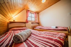 two beds in a room with a attic at Liptovské Drevenice-chaty in Liptovský Mikuláš