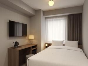 een hotelkamer met een bed en een televisie bij The Knot Utsunomiya in Utsunomiya +11 foto's