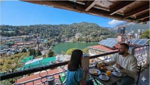 een man en een vrouw aan een tafel met borden eten bij Naini Hill View Boho in Nainital