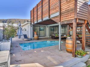 a patio with a swimming pool and a house at Hermanus Cliff Path Lodge - No Load-shedding in Hermanus