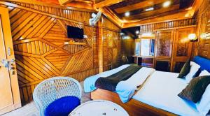 een slaapkamer met een bed en 2 stoelen in een kamer bij Naini Hill View Boho in Nainital +21 foto's