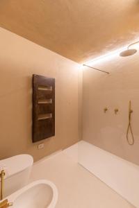 Re Carlo - Ortigia Luxury Suite في سيراكوزا: حمام مع مرحاض ومغسلة ودش