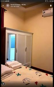 a bedroom with two beds and a door with a window at BONNIE HOMESTAY Mui Ne in Mui Ne